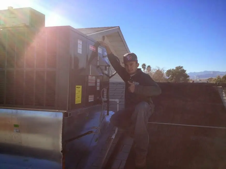 HVAC technician performing Heat Pump Repair on a rooftop unit in Steiner Ranch